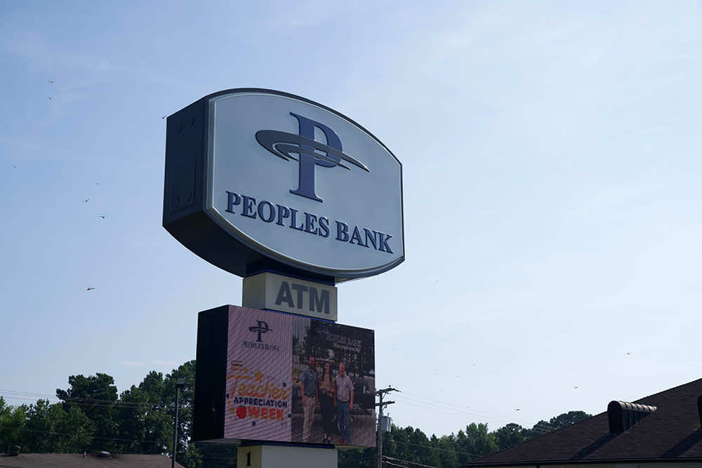 The Peoples Bank road sign with an ATM marker and a digital message board