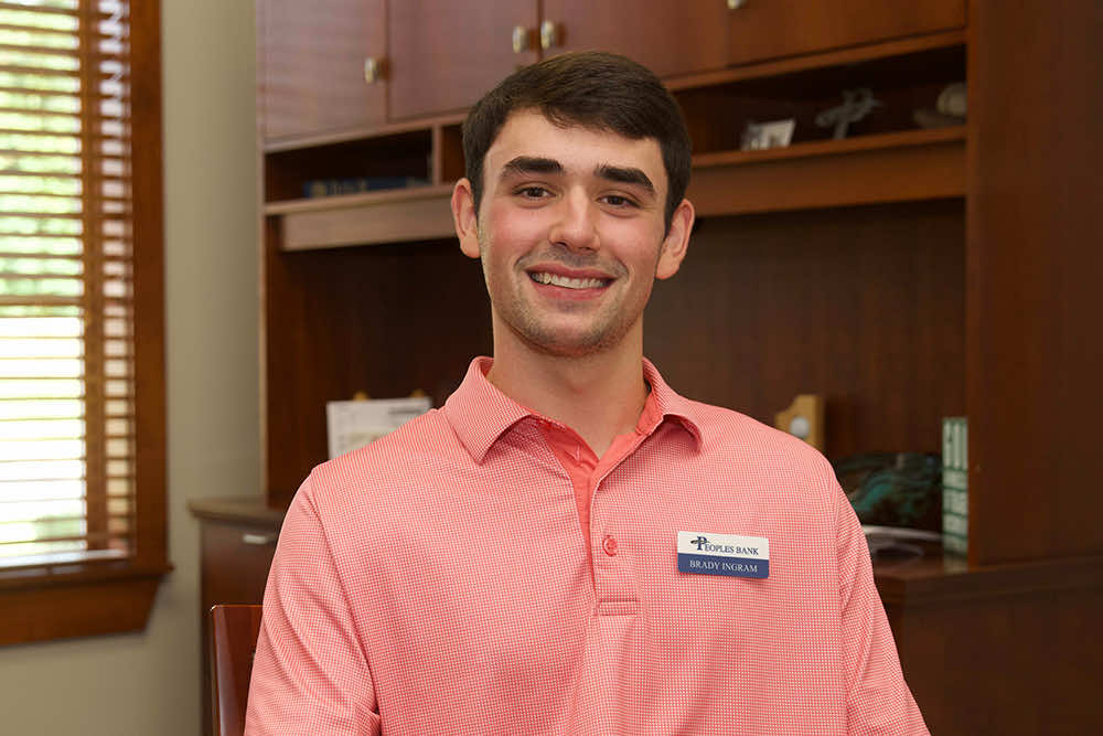 A young Peoples Bank banker smiling in an office