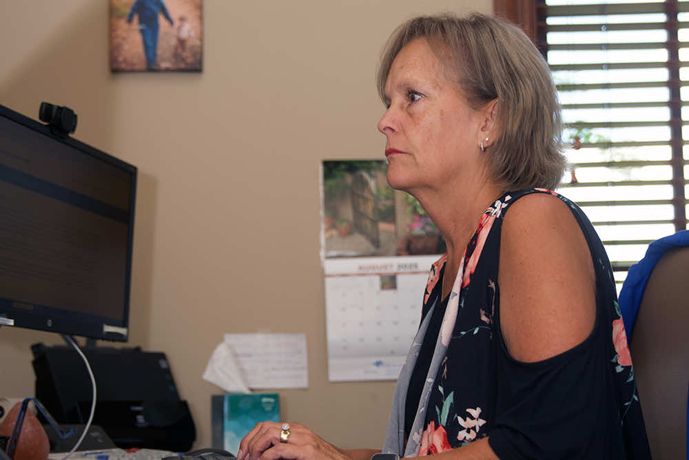 A Peoples Bank employee concentrating on a computer screen at an office desk